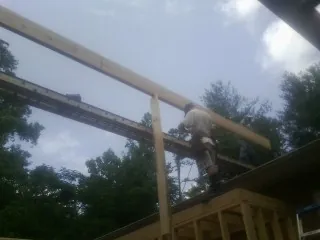 Carpenter setting a ridge beam over a new addition frame — Ice Dam Removal by Roofing Brothers in Montgomery Village