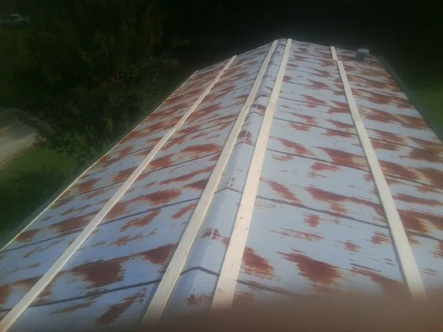 Rusted metal roof panels with new wood purlins before replacement — Storm Damage Roof Repair in Montgomery Village by Roofing Brothers