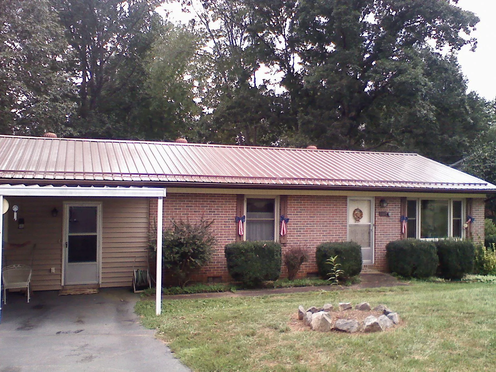 Bronze metal roof and carport on a brick ranch home — Roof Repair work by our crew in Montgomery Village
