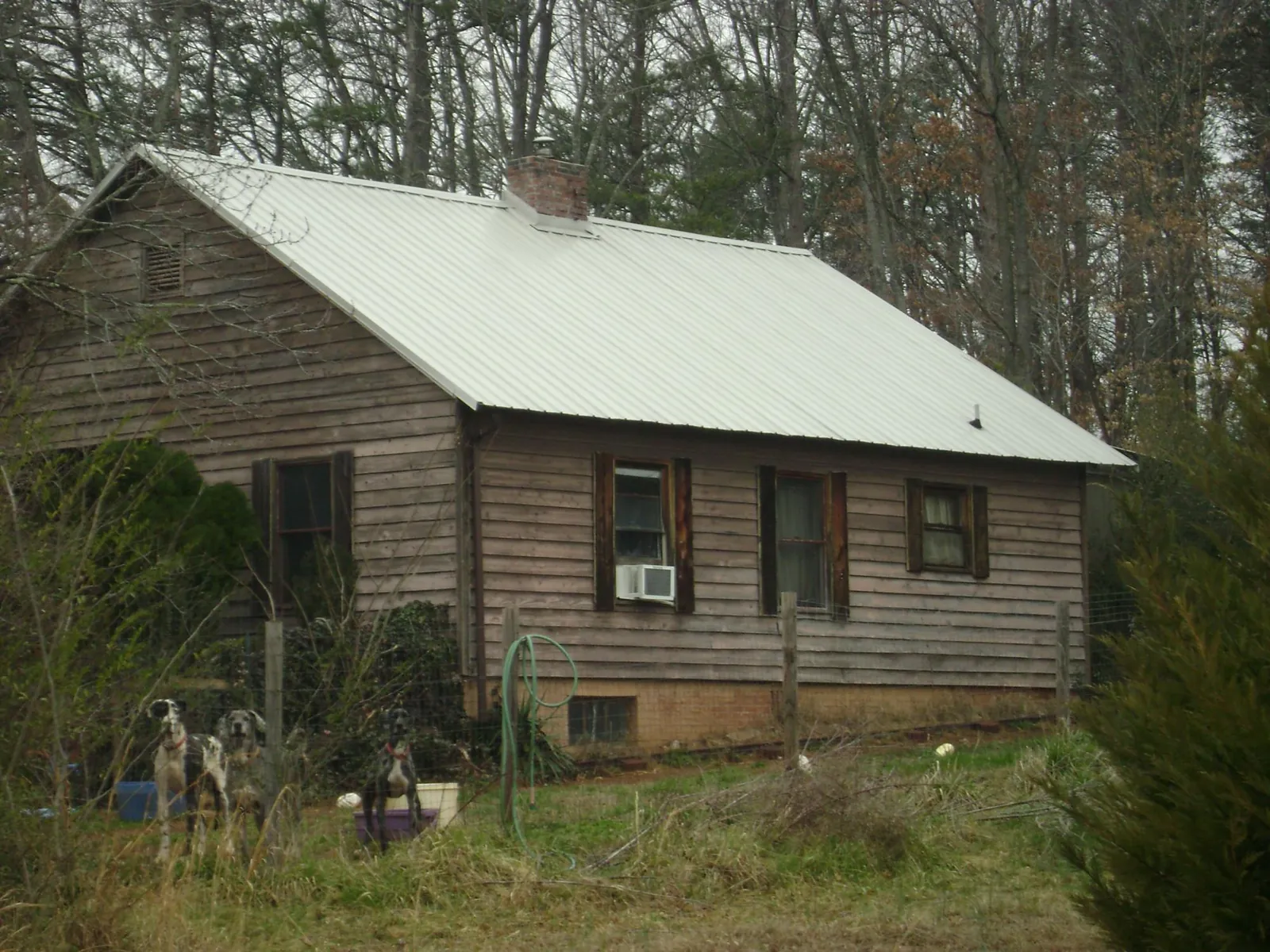White metal roof on an old wood sided farmhouse, from a Metal Roof Installation job in Montgomery Village